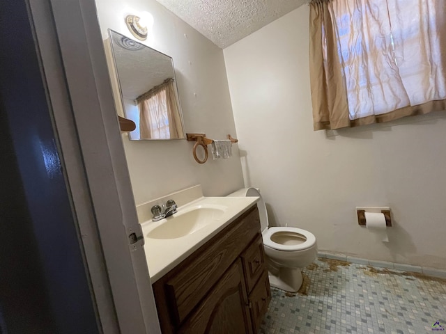 half bath with a textured ceiling, toilet, and vanity