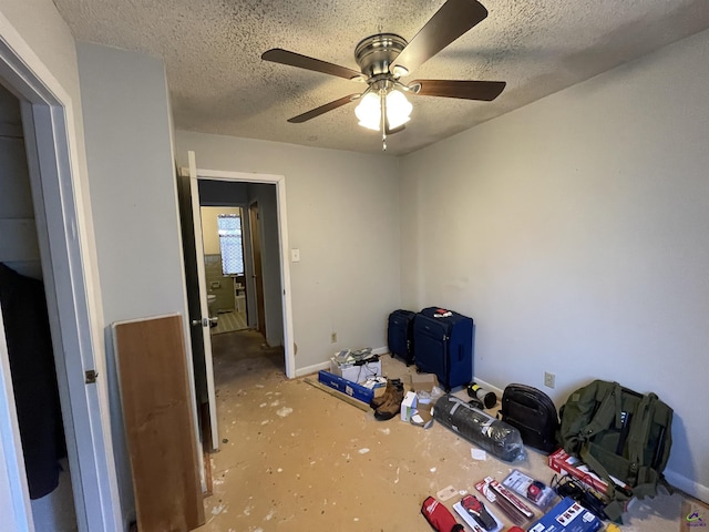 unfurnished bedroom with a ceiling fan, baseboards, and a textured ceiling