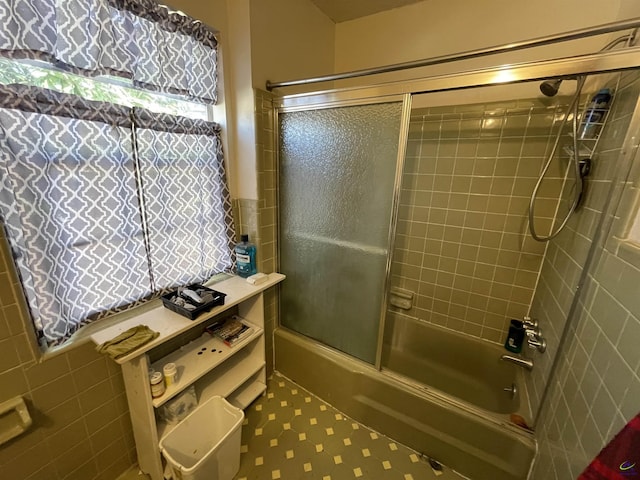 full bathroom featuring tile patterned floors and shower / bath combination with glass door