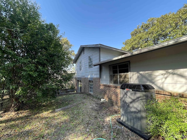 view of side of property with brick siding and central AC unit