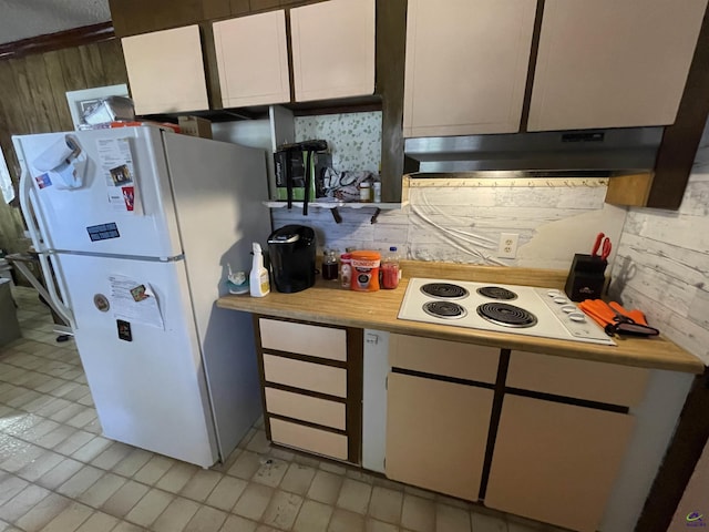 kitchen with under cabinet range hood, white appliances, white cabinets, and light countertops