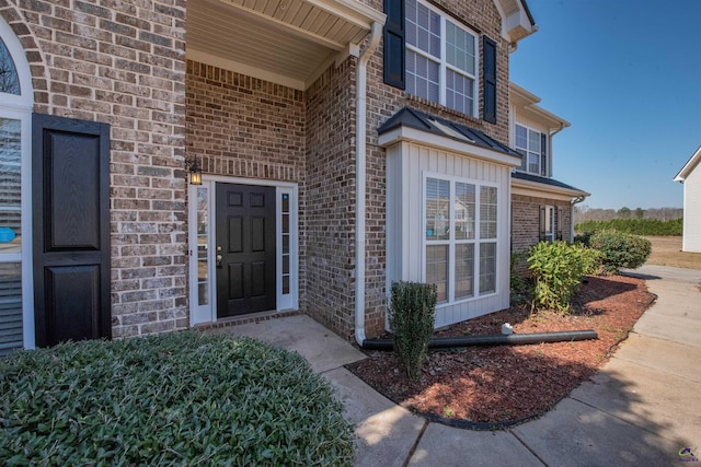 entrance to property featuring brick siding and board and batten siding