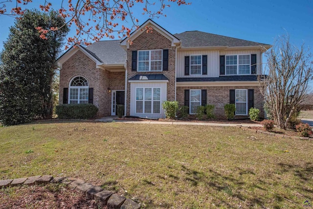 traditional-style home with brick siding, a front lawn, and roof with shingles