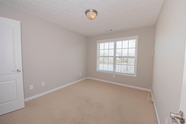 spare room featuring visible vents, baseboards, a textured ceiling, and carpet floors