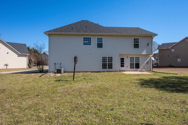 rear view of property featuring a yard, a patio area, and central AC