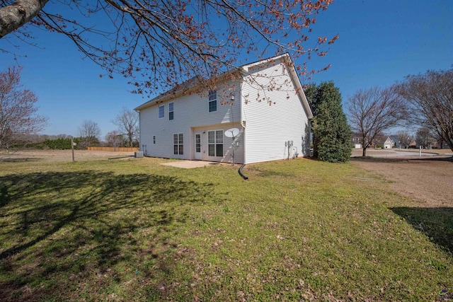 back of property featuring a patio and a lawn