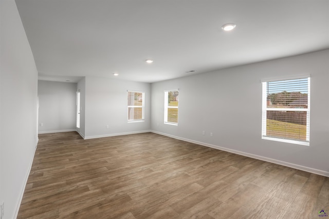 empty room featuring recessed lighting, baseboards, and wood finished floors