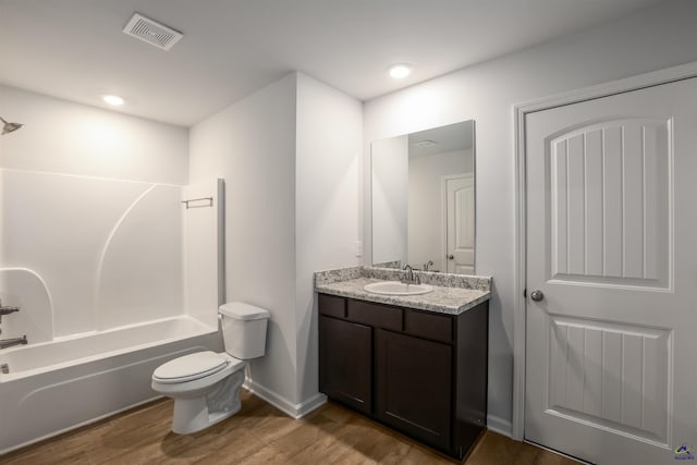 bathroom with visible vents, toilet, wood finished floors, tub / shower combination, and vanity