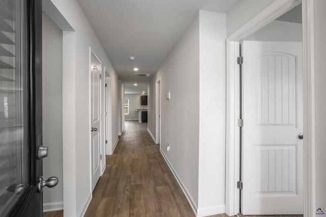 corridor with recessed lighting, visible vents, baseboards, and wood finished floors