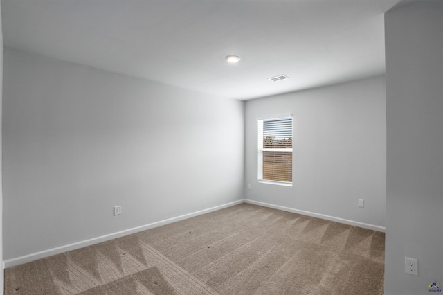 unfurnished room featuring visible vents, baseboards, and carpet