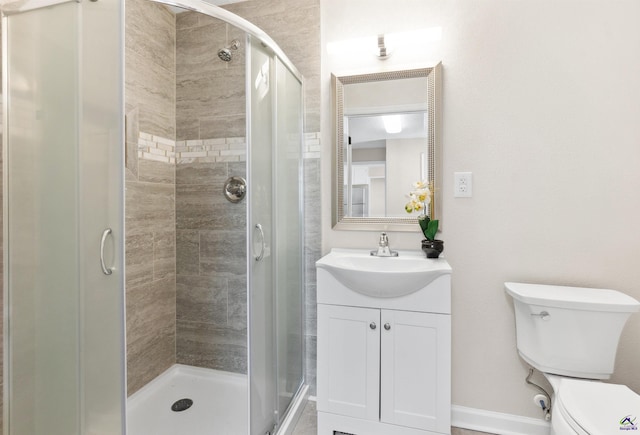 full bathroom featuring vanity, toilet, baseboards, and a stall shower