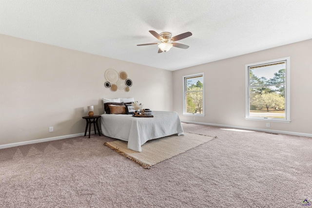 bedroom featuring ceiling fan, carpet flooring, baseboards, and a textured ceiling