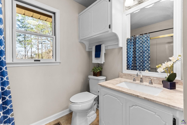 bathroom with vanity, a shower with curtain, baseboards, tile patterned floors, and toilet