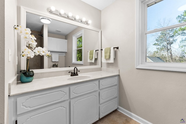 bathroom with visible vents, vanity, and baseboards