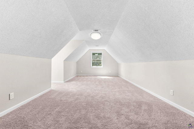 bonus room featuring lofted ceiling, light colored carpet, visible vents, and baseboards