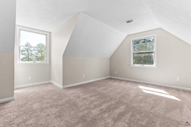 bonus room featuring vaulted ceiling, visible vents, baseboards, and carpet floors