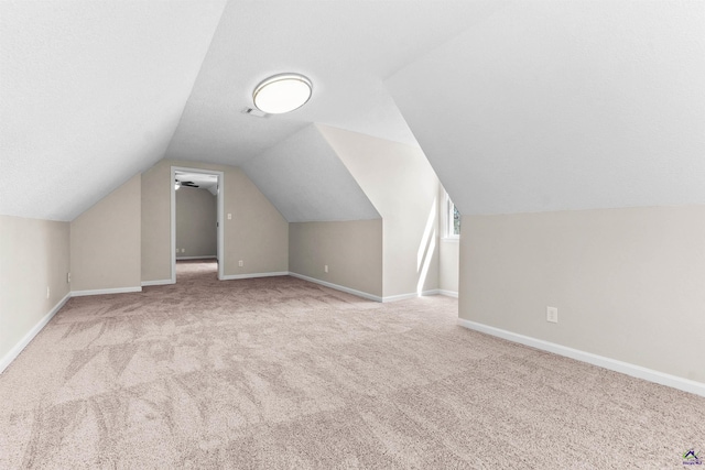 bonus room with vaulted ceiling, a textured ceiling, baseboards, and carpet floors