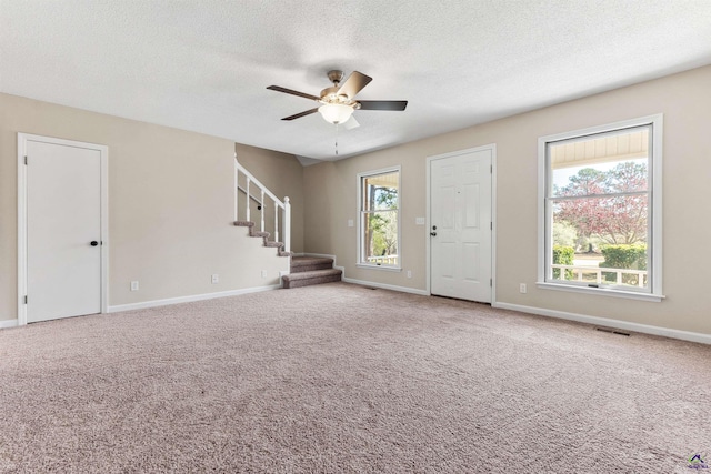 interior space featuring stairway, plenty of natural light, baseboards, and visible vents