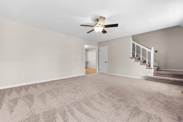 unfurnished living room featuring stairs, carpet flooring, a ceiling fan, and baseboards