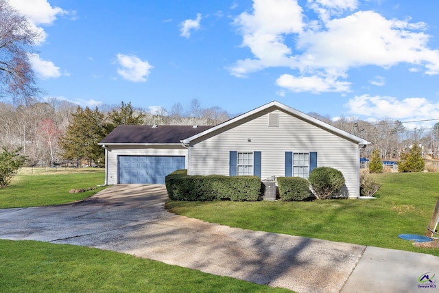 view of front of house with concrete driveway, an attached garage, central AC unit, and a front yard