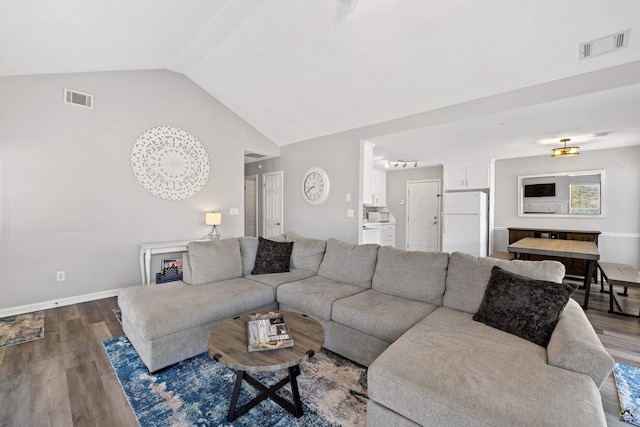 living room featuring visible vents, lofted ceiling, and wood finished floors