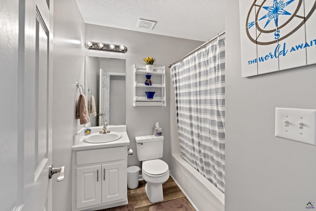 full bath featuring vanity, wood finished floors, visible vents, a textured ceiling, and toilet