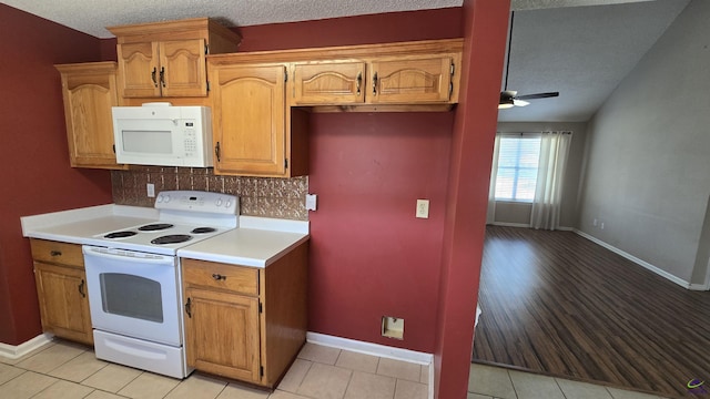 kitchen with backsplash, light countertops, white appliances, a textured ceiling, and a ceiling fan