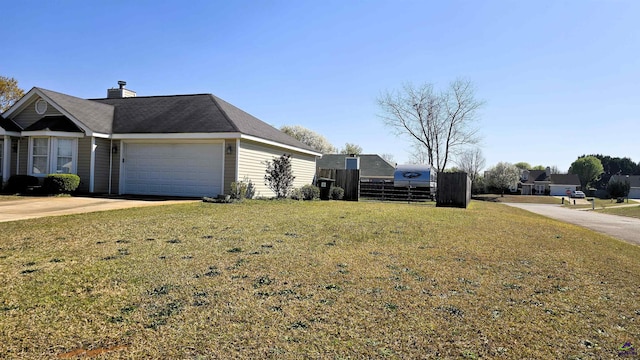 view of side of home featuring fence, concrete driveway, a lawn, a chimney, and a garage