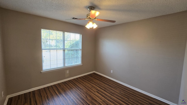 unfurnished room with visible vents, baseboards, dark wood-style floors, a textured ceiling, and a ceiling fan