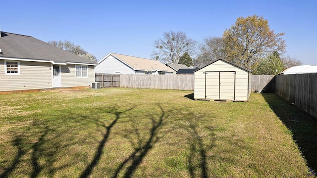 view of yard with cooling unit, an outbuilding, a fenced backyard, and a shed