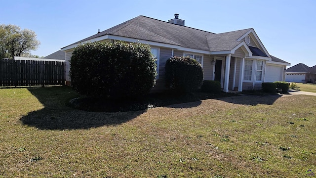 view of home's exterior featuring a lawn, a chimney, and fence