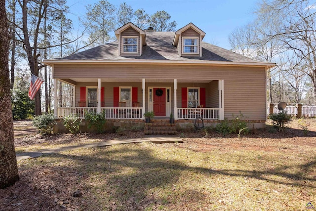 view of front of house with a porch, fence, and a front yard