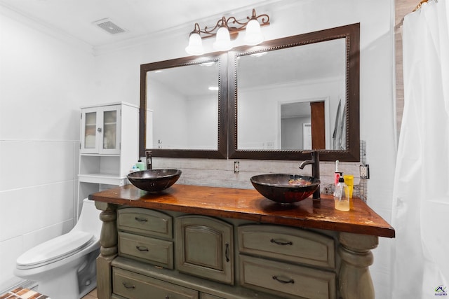 full bath with a sink, visible vents, ornamental molding, and decorative backsplash