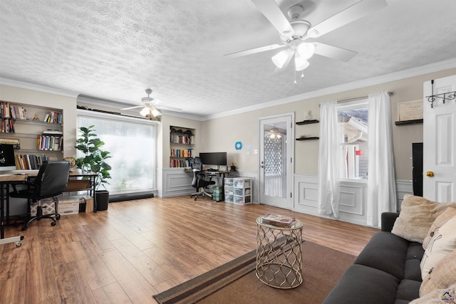 interior space with plenty of natural light, built in shelves, a textured ceiling, and wood finished floors