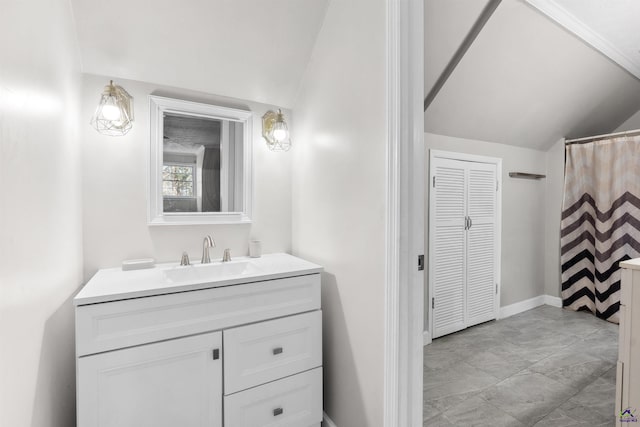 bathroom featuring vanity, lofted ceiling, baseboards, and a closet