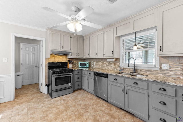 kitchen featuring light stone countertops, a sink, gray cabinetry, stainless steel appliances, and under cabinet range hood