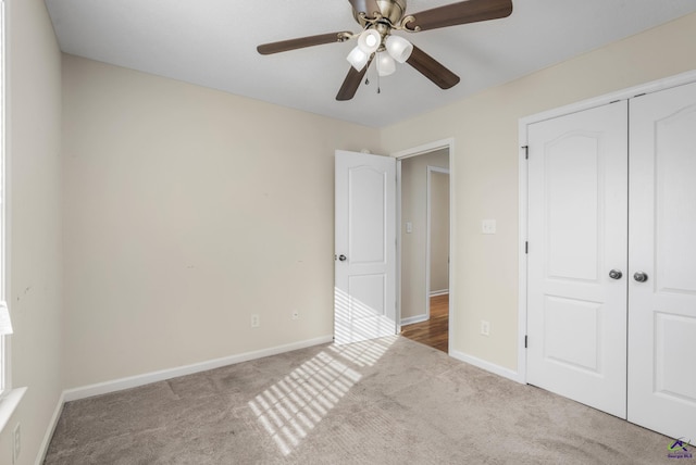 unfurnished bedroom with baseboards, carpet floors, a closet, and ceiling fan