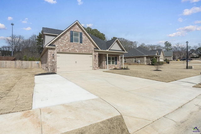 view of front of home with an attached garage, fence, brick siding, and driveway