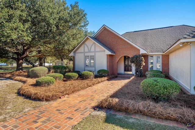 tudor-style house with brick siding and roof with shingles