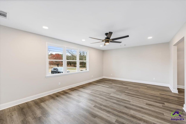 spare room with recessed lighting, baseboards, and wood finished floors