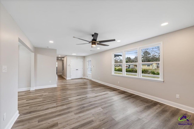 unfurnished living room featuring recessed lighting, baseboards, and wood finished floors