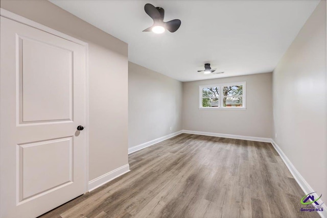 unfurnished room featuring wood finished floors, baseboards, and ceiling fan