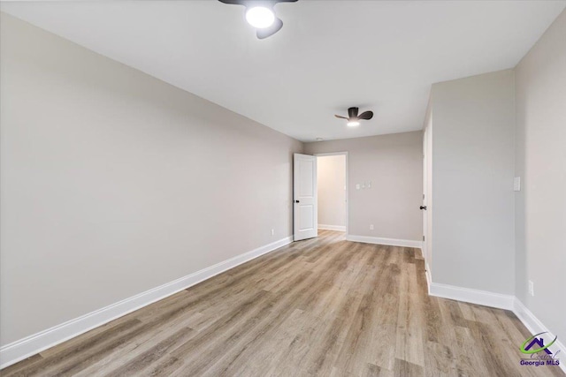 unfurnished room featuring baseboards and light wood-style floors