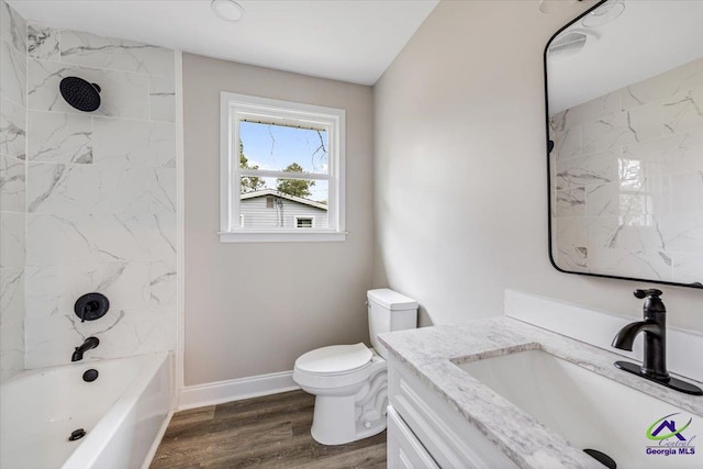 bathroom featuring baseboards, toilet, shower / bath combination, wood finished floors, and vanity