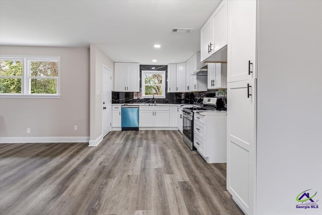 kitchen with baseboards, visible vents, decorative backsplash, appliances with stainless steel finishes, and light wood-type flooring