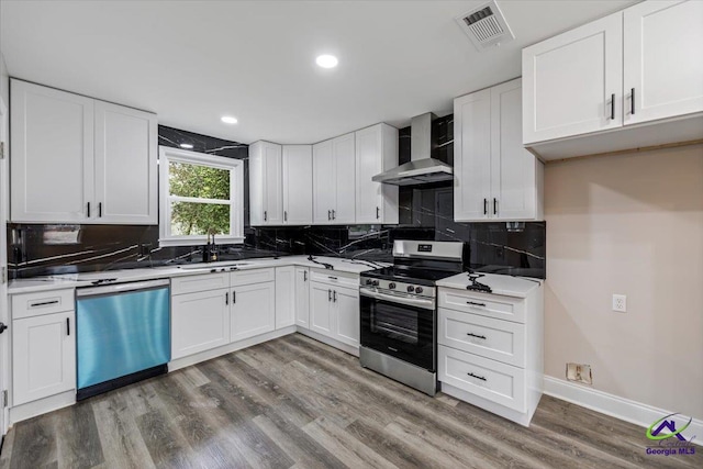 kitchen with visible vents, dishwasher, electric range, wall chimney exhaust hood, and a sink