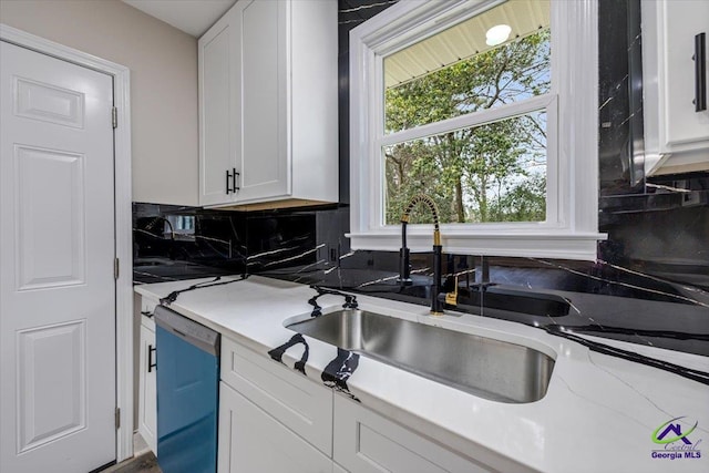 kitchen with a sink, dishwashing machine, tasteful backsplash, and white cabinets