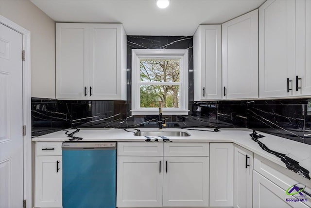 kitchen featuring dishwasher, white cabinets, and a sink