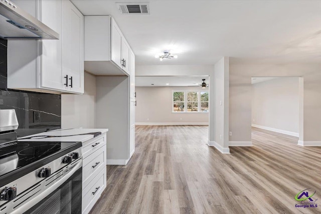 kitchen with tasteful backsplash, visible vents, under cabinet range hood, open floor plan, and stainless steel range with electric cooktop