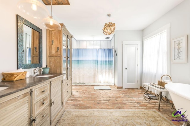 full bath with brick floor, a soaking tub, and vanity